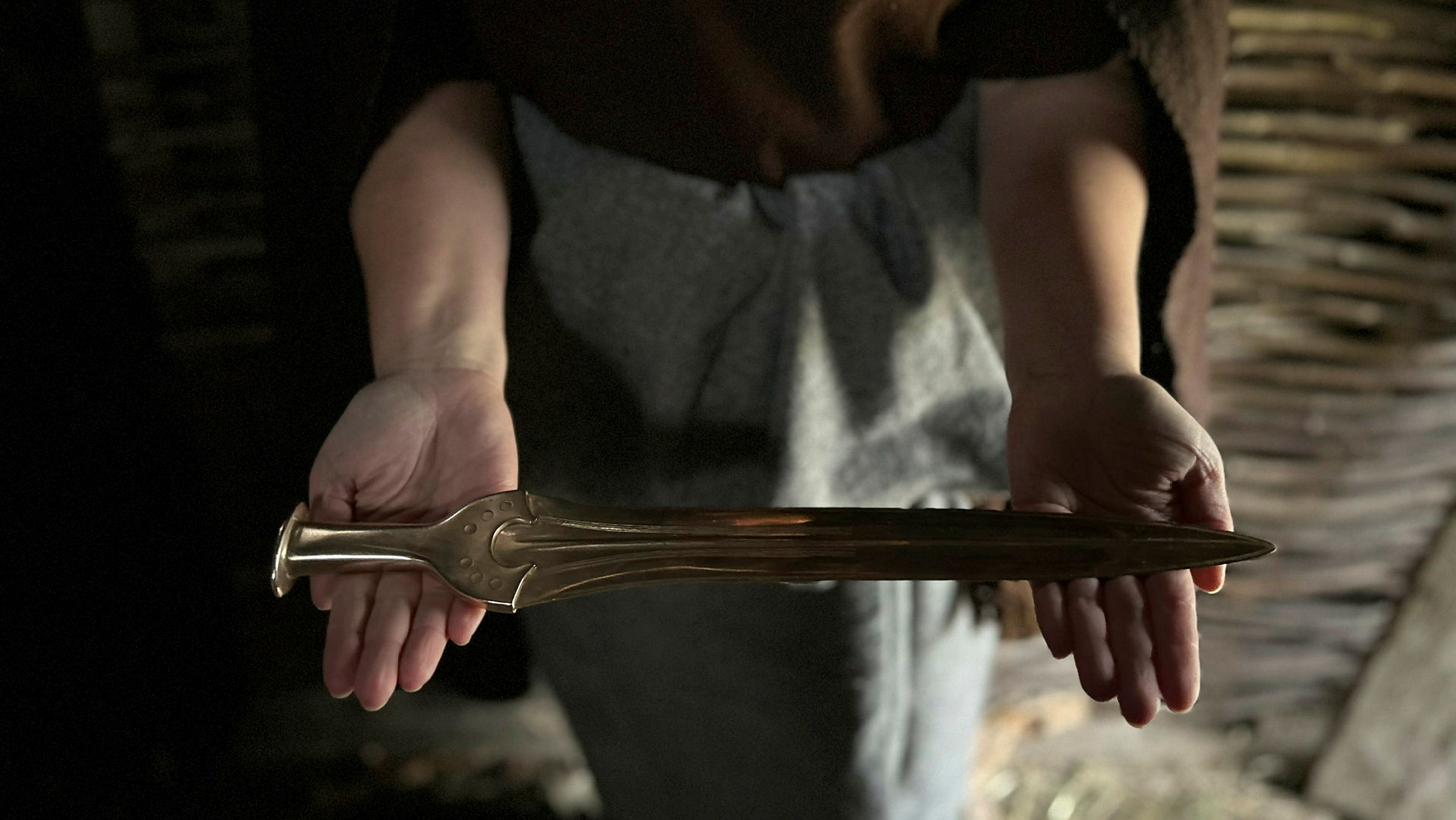 kvinna håller bronssvärd med båda händerna