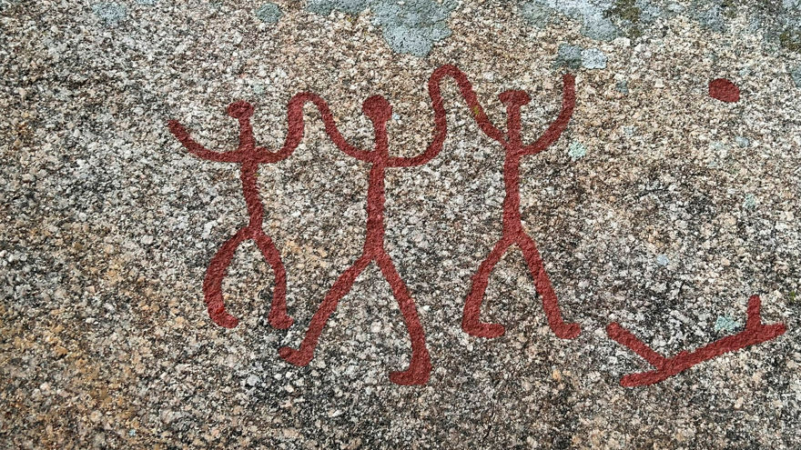 hällristningar med tre människofigurer som håller hand