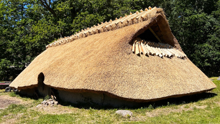 Långhus med nytt vasstak utomhus i bronsåldersgården.