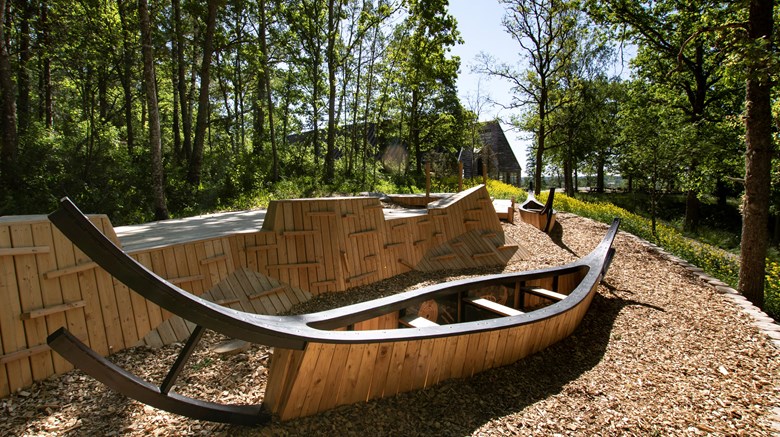 Lekplatsen med båtar i trä, med museet i bakgrunden.