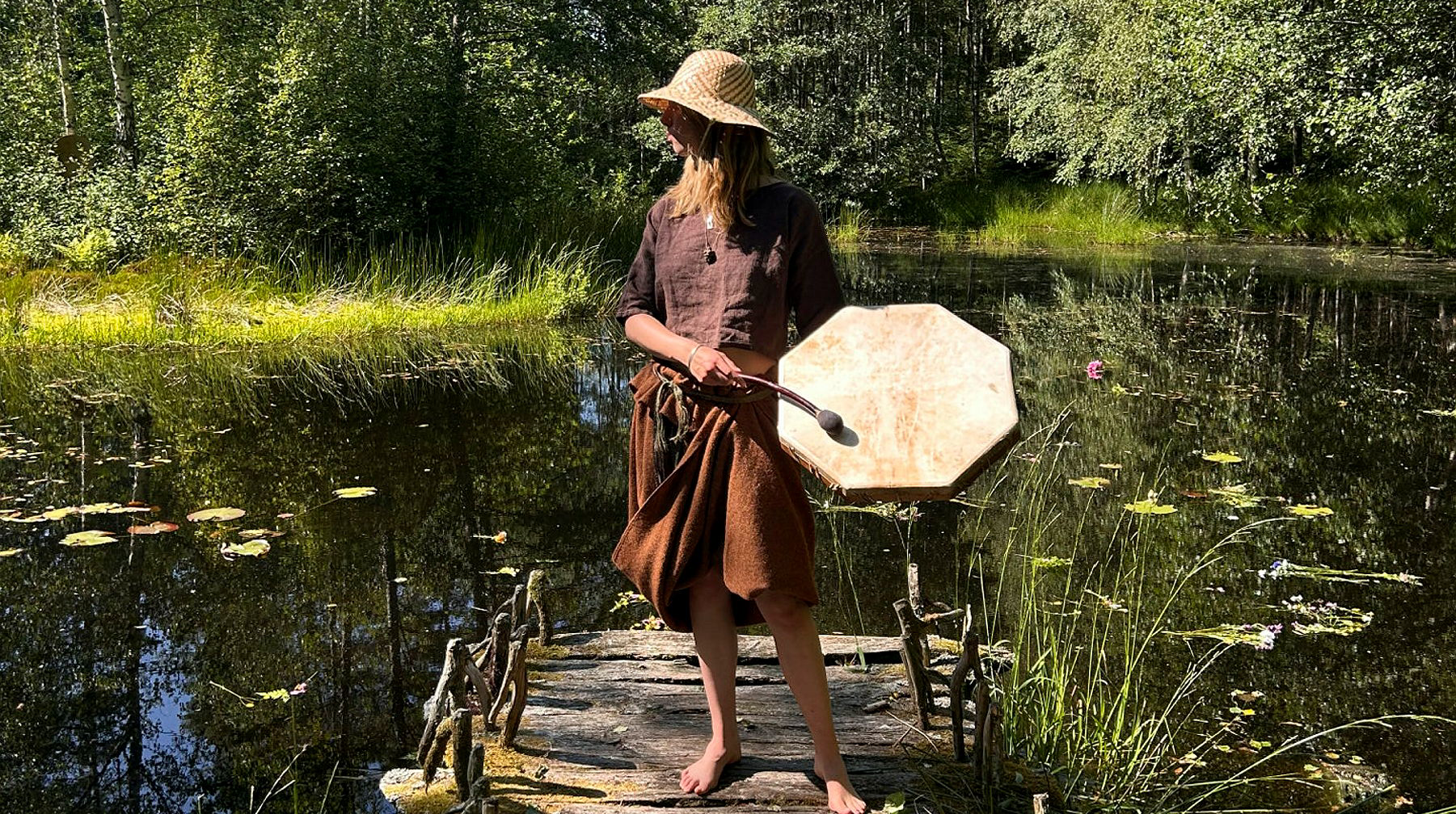 a woman with a drum dressed in bronze age clothing