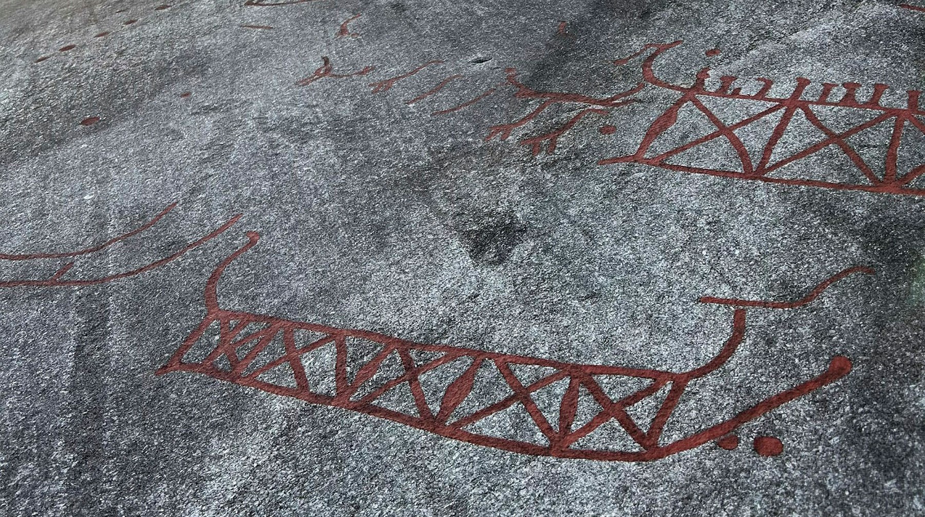 Hällristning båt målad röd.