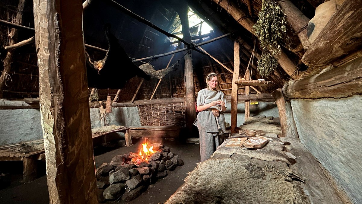  Eine Frau in einem Langhaus auf einem Bauernhof aus der Bronzezeit.